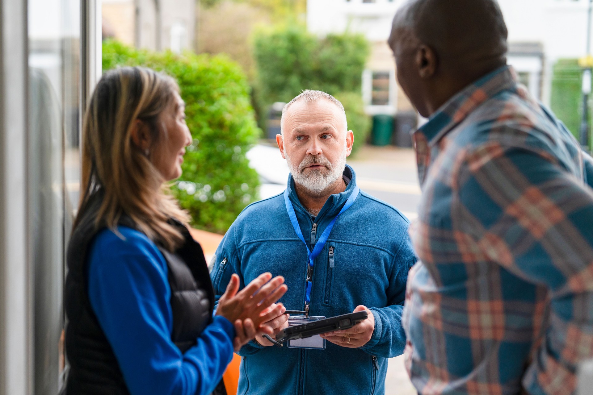 Community members engage with service provider outside on a vibrant day