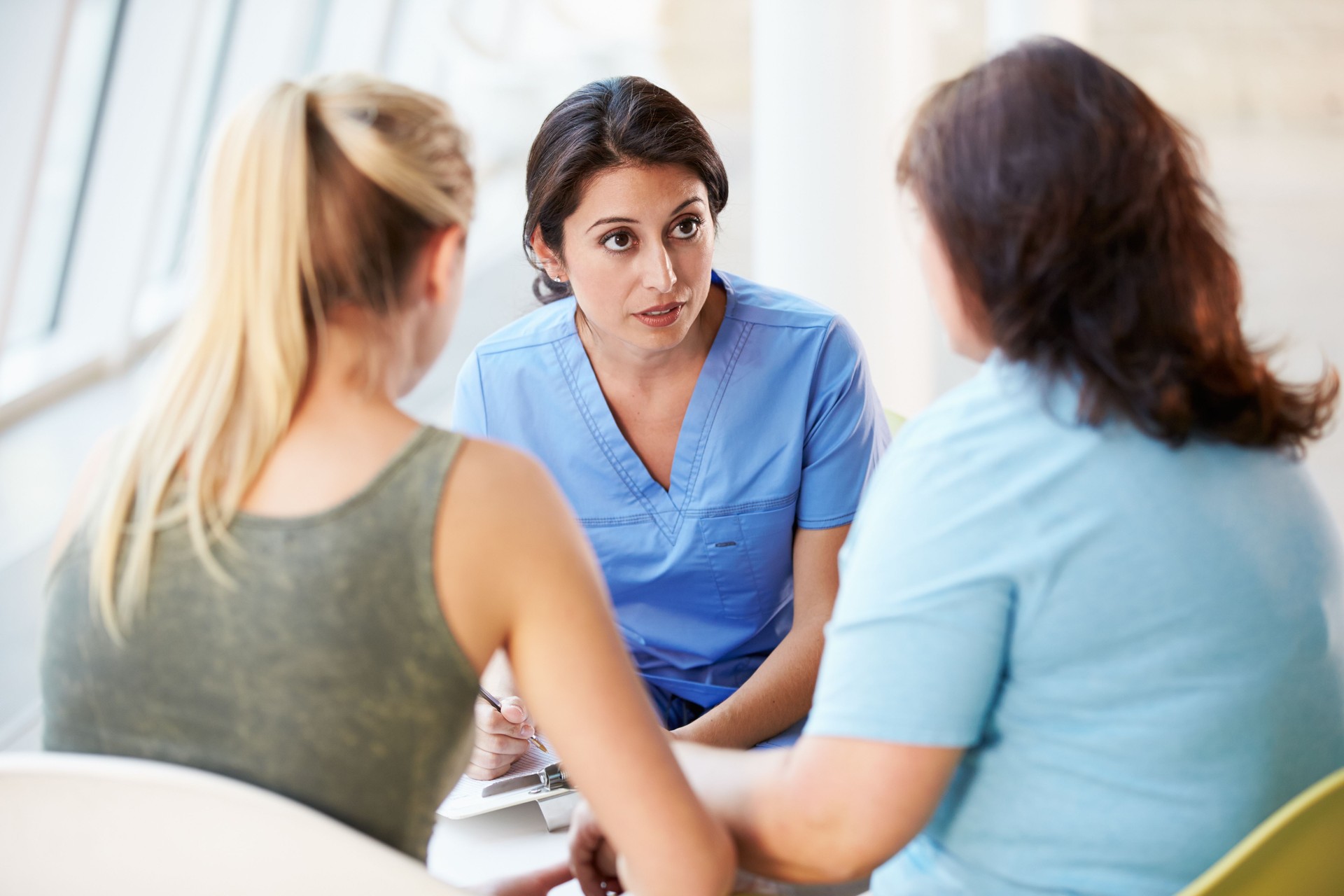 Nurse with concerned look meeting with girl and mother